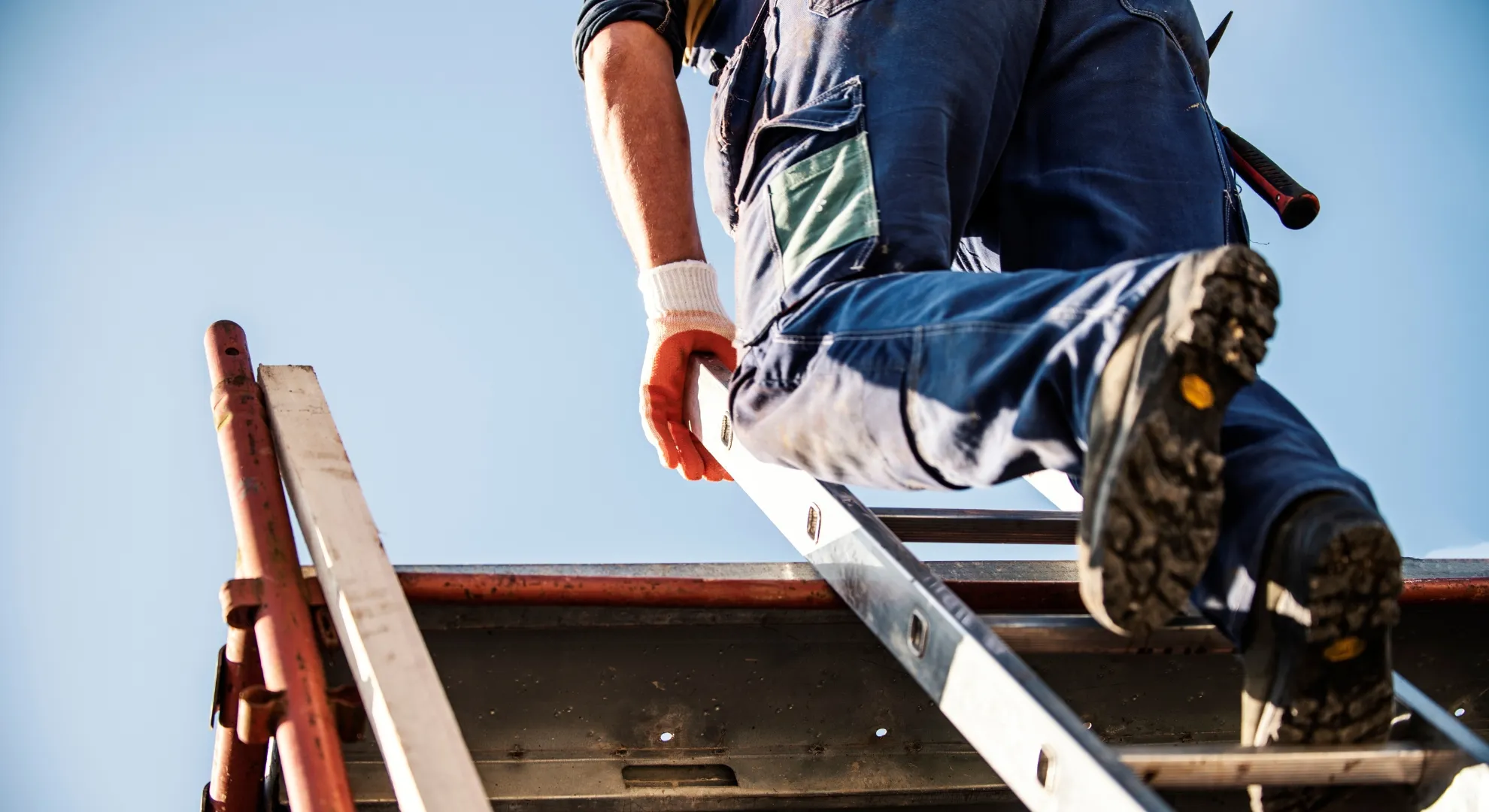 Roofing contractor climbing ladder